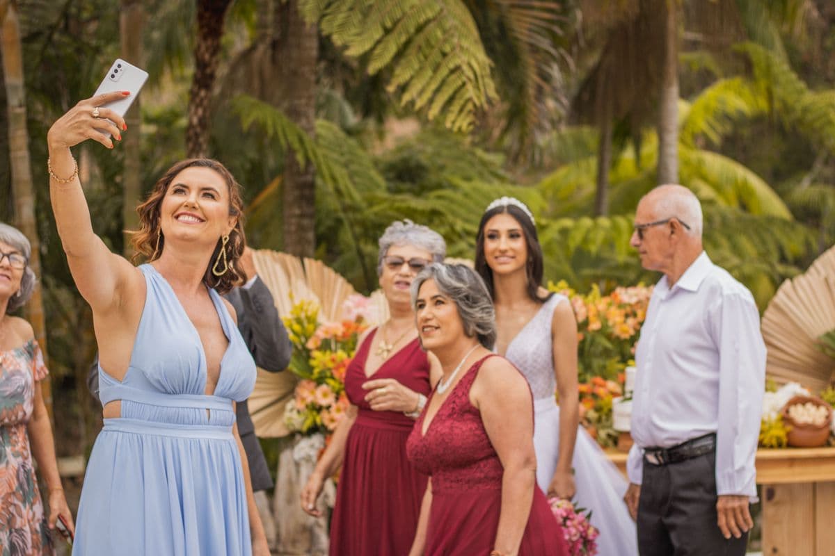 Wedding guests taking a group selfie outdoors